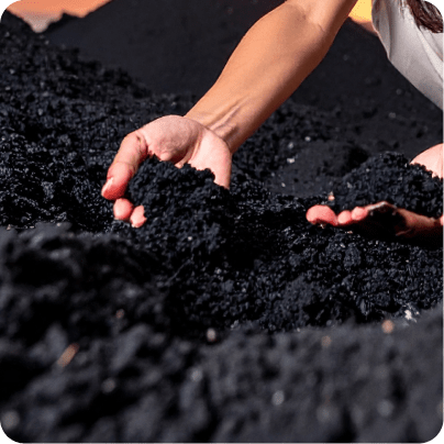 Person holding and examining black volcanic soil with both hands